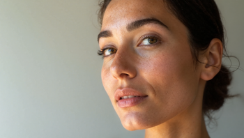 Woman in her late thirties with healthy, firm skin photographed in natural lighting showing skin texture and radiance