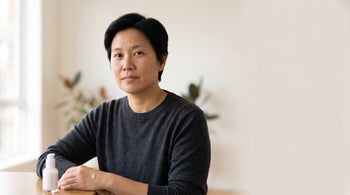 43-year-old East Asian Australian non-binary person with medium skin tone shown in a close-up portrait with calm, clear skin in soft natural light