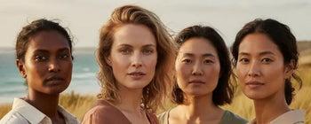 Four diverse Australian women aged 35 to 65 standing together outdoors, wearing natural makeup and relaxed linen clothing. Their skin is radiant and real, set against a soft sunlit Australian landscape — reflecting strength, diversity, and confidence in s